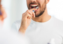 Man brushing his teeth at home